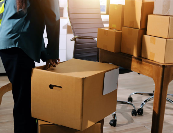 A woman packs boxes in an business office to move them into storage.